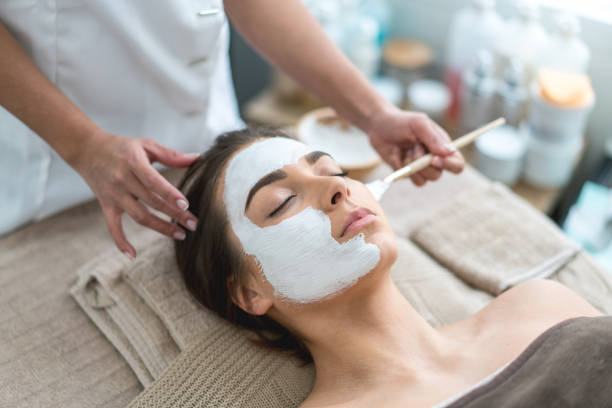 Portrait of a beautiful woman getting a facemask at the spa and taking care of her skin - beauty concepts